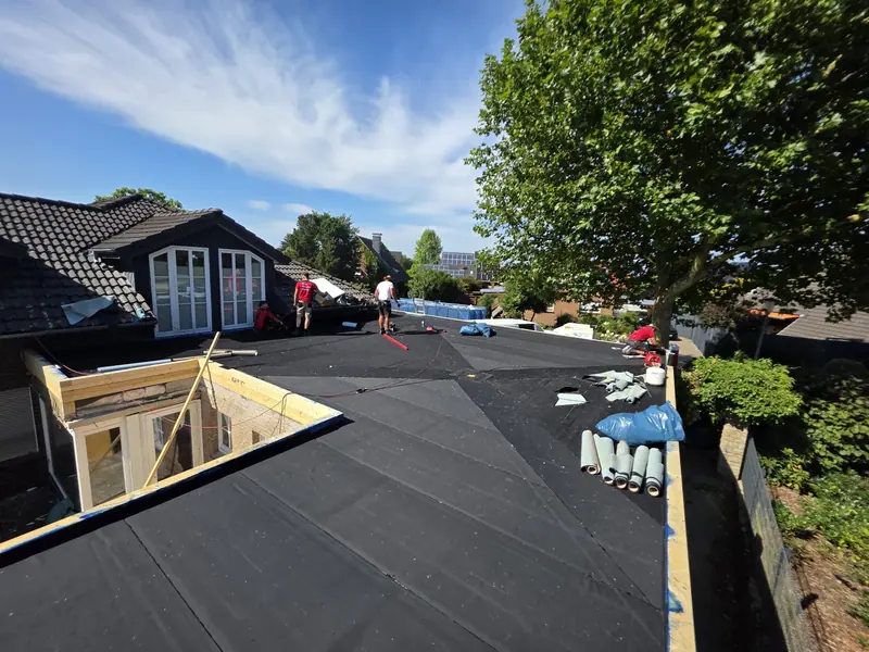 Flachdachsanierung neben einer Gaube, Material auf dem Dach