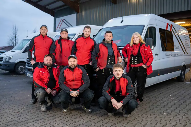 Team von Oliver Rasche Holzbau vor den Firmenfahrzeugen