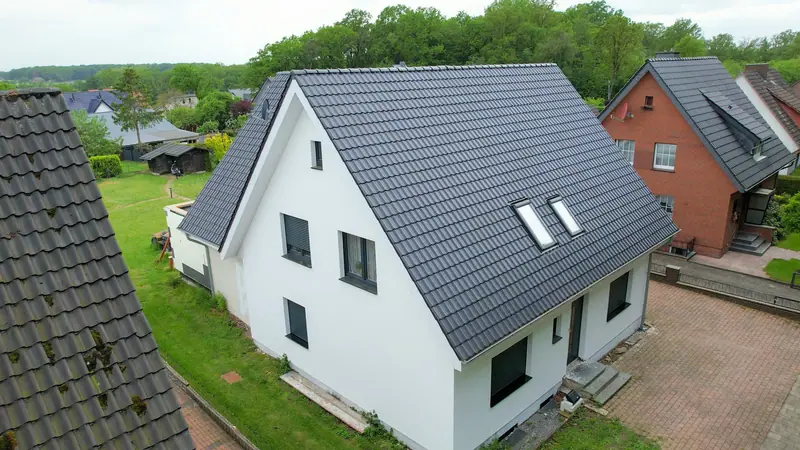 Weißes Einfamilienhaus mit neuem anthrazitfarbenem Dach, Luftaufnahme